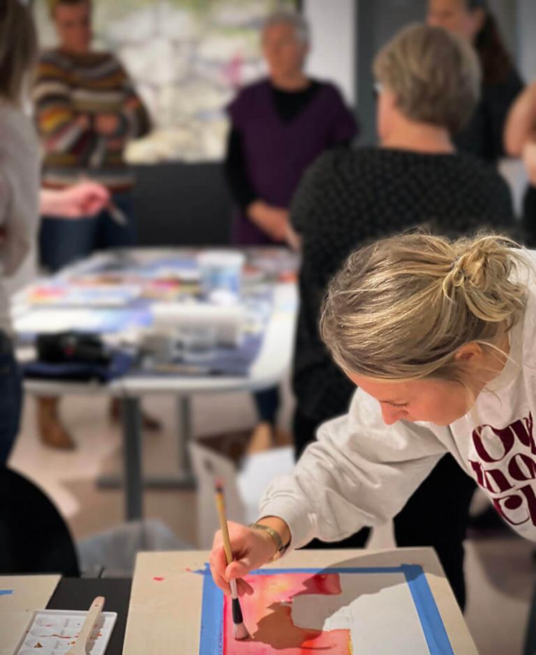 One of the participants working with a painting during the workshop at the Nordic Institute on Åland.